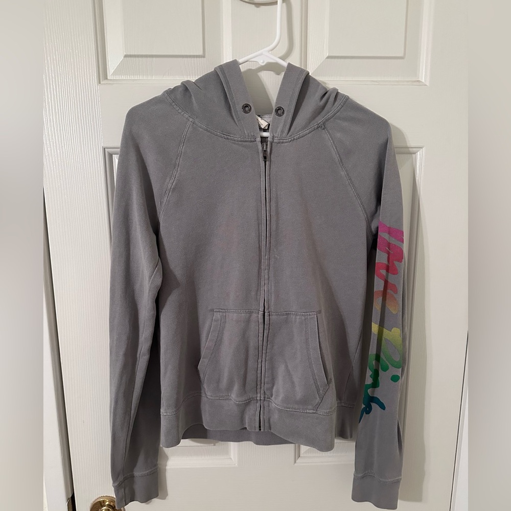 PINK Victoria’s Secret Zip Up Hoodie, with Colorful lettering down the sleeve.
